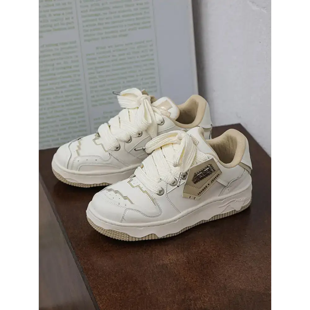 Krem rengi tabanlı, yıpranmış beyaz Nike Air Force 1 spor ayakkabı çifti.